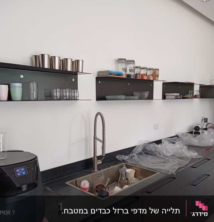 אדם מתקין מדף עם מקדחה וכלי עבודה